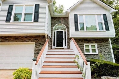 View of exterior entry featuring stone siding and an attached garage