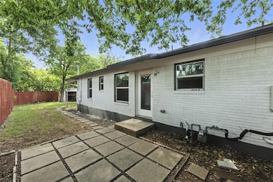 Rear view of house featuring brick siding, a fenc