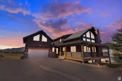 View of front of property featuring asphalt driveway, board and batten siding, a large porch, a chimney, and an attached garage