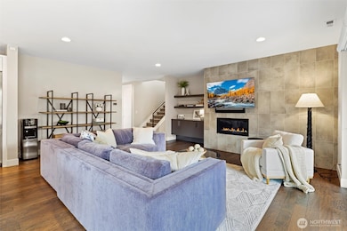 Large great room with high ceilings and grand chef's kitchen. Gas Fireplace, custom mounted TV, floor to ceiling tile surround.