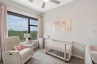 Bedroom with carpet floors, a crib, and ceiling fan