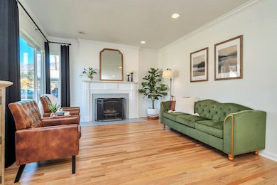 Living area featuring crown molding, light wood-style floors, a fireplace, and recessed lighting