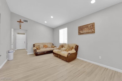 Living area featuring baseboards, light wood finis