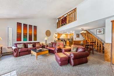 Carpeted living room with a baseboard heat, stairw