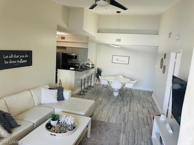 Living area with ceiling fan, high vaulted ceiling, and wood finished floors