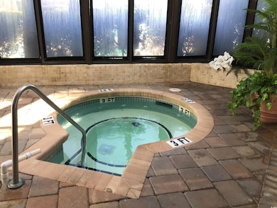 View of swimming pool with a hot tub