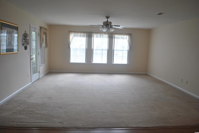 Carpeted spare room with baseboards and ceiling fan