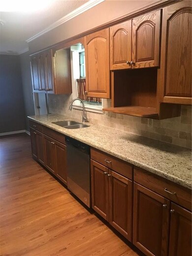 One side of kitchen has stainless steel dishwasher