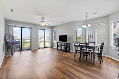 Dining space featuring a chandelier, dark wood-style flooring, and ceiling fan