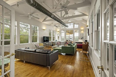Sunroom / solarium with wood finished floors, a high ceiling, and french doors