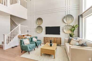 PHOTO FROM SIMILAR MODEL HOME. COLORS, OPTIONS, AND FEATURES WILL VARY: Living room featuring stairs, a towering ceiling, and wood finished floors