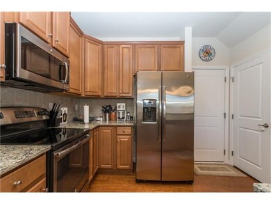 Kitchen has granite counters, tile backsplash, stainless appliances and hardwood floors