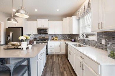 Open and inviting throughout, this stunning kitchen will be the focal point of gatherings for years to come. (model photo) Finishes will vary.