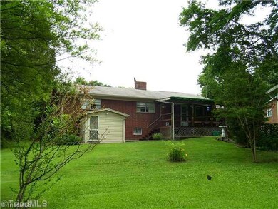 Exterior Back. Covered deck looks out over nicely landscaped back yard.