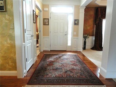 Grand entrance with durable hardwood floors, wainscoting and decorative trim. 