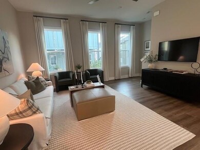 Living room featuring wood finished floors, plenty of natural light, and a ceiling fan