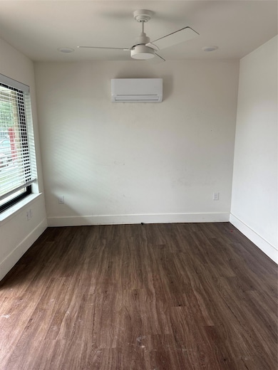 Unfurnished room featuring baseboards, wood finis