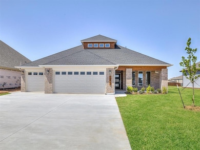View of front of property with brick siding, a shingled roof, a garage, a front lawn, and concrete driveway