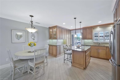 Kitchen featuring crown molding, a sink, stone cou