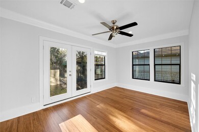Large primary bedroom with dual patio doors. The d