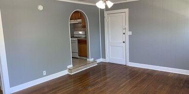 Spare room featuring crown molding, wood-type floo