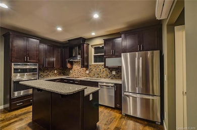 Spacious modern kitchen, granite countertops, stainless appliances, tiled backsplash
