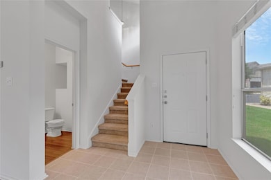 Entrance foyer featuring stairway and light tile 