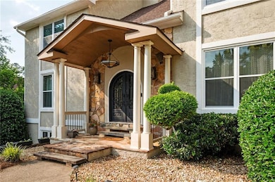 Doorway to property featuring stucco siding and stone siding