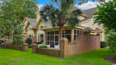 Back of property with a sunroom, a shingled roof, a lawn, and a chimney