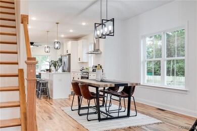 Dining space with ceiling fan with notable chandel