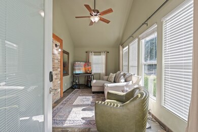 Bright living area with tall windows bringing in generous natural light and a comfortable seating arrangement.