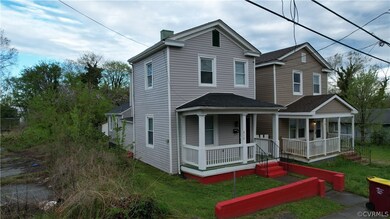 Rear view of house with covered porch and a lawn