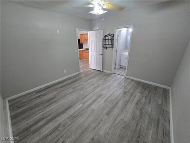 Unfurnished bedroom with light wood-type flooring, a ceiling fan, and ensuite bathroom