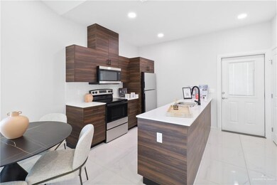 Kitchen with quartz countertops, appliances with stainless steel finishes, marble finish floor, modern cabinets, and a sink