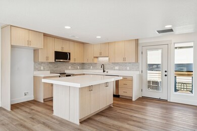 Kitchen featuring light brown cabinets, a center island, light wood-style flooring, modern cabinets, and recessed lighting
