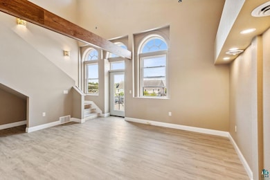Entrance foyer with beamed ceiling, hardwood / wood-style floors, and a towering ceiling