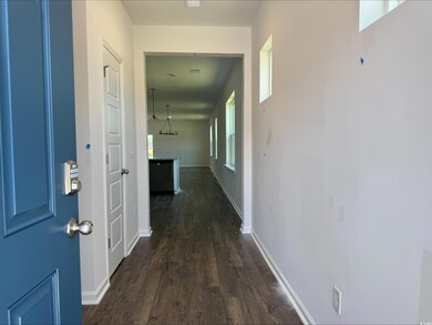 Hall featuring dark wood-style flooring and baseboards