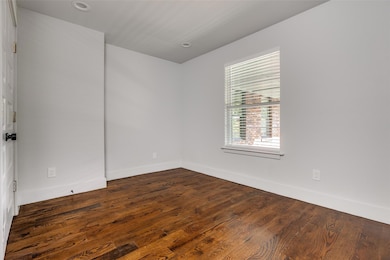 Empty room featuring dark wood-type flooring