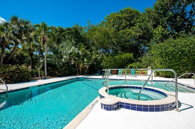 View of pool with a pool with connected hot tub and view of scattered trees