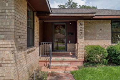 Property entrance with a shingled roof, brick sid