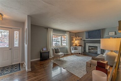 Living room with a textured ceiling, dark wood-type flooring, and a fireplace