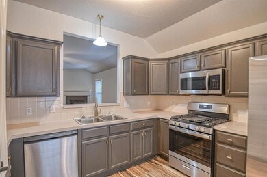 Kitchen with lofted ceiling, appliances with stain