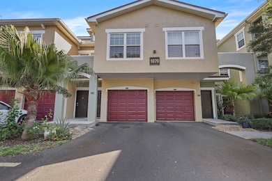 View of front facade with stucco siding, driveway, and a garage