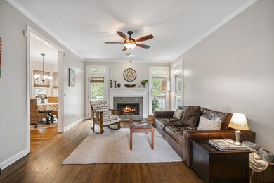 Large Living Room at the back of the home includes refinished hardwood floors, a gas fireplace plus access to the deck and fenced yard