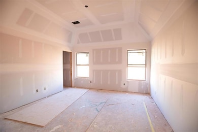 Unfurnished room featuring plenty of natural light and vaulted ceiling
