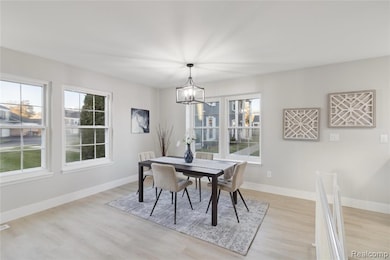 Dining room featuring light wood-type flooring and a chandelier