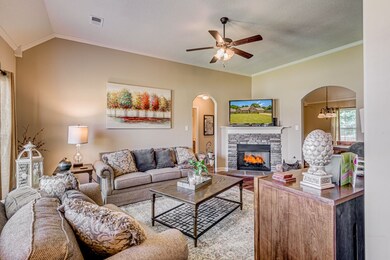 Great sized family room with Wood Laminate floors, feature gas fireplace, ceiling fan and neutral decor