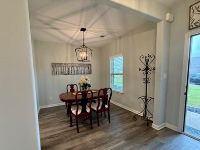 Dining room featuring dark wood-type flooring, baseboards, and a chandelier