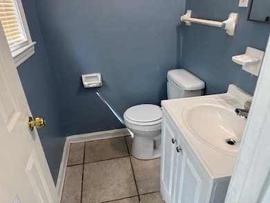 Bathroom featuring baseboards, toilet, tile patterned flooring, and vanity