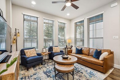 Living room featuring baseboards, a ceiling fan, w
